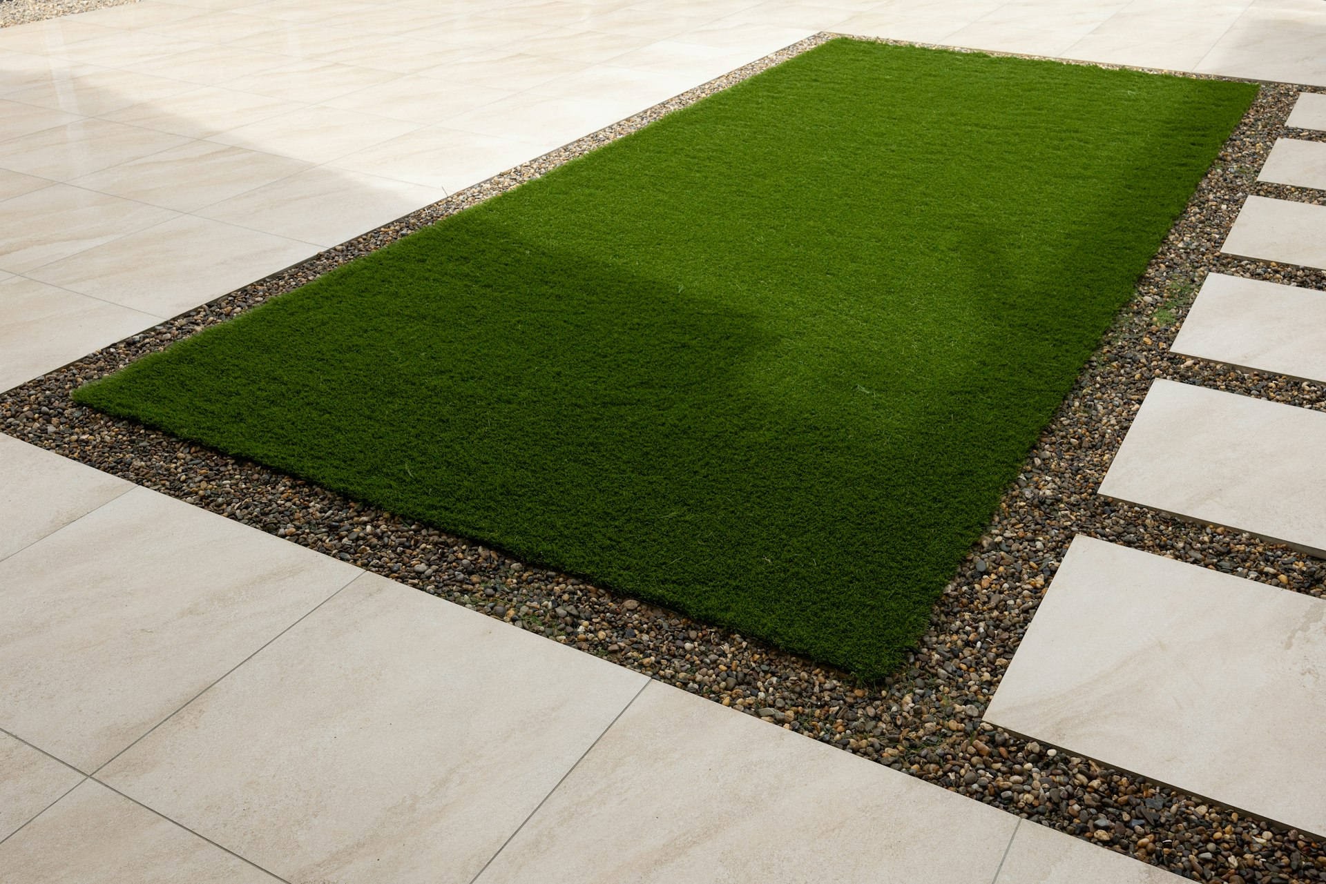 a green grass area in the middle of a walkway